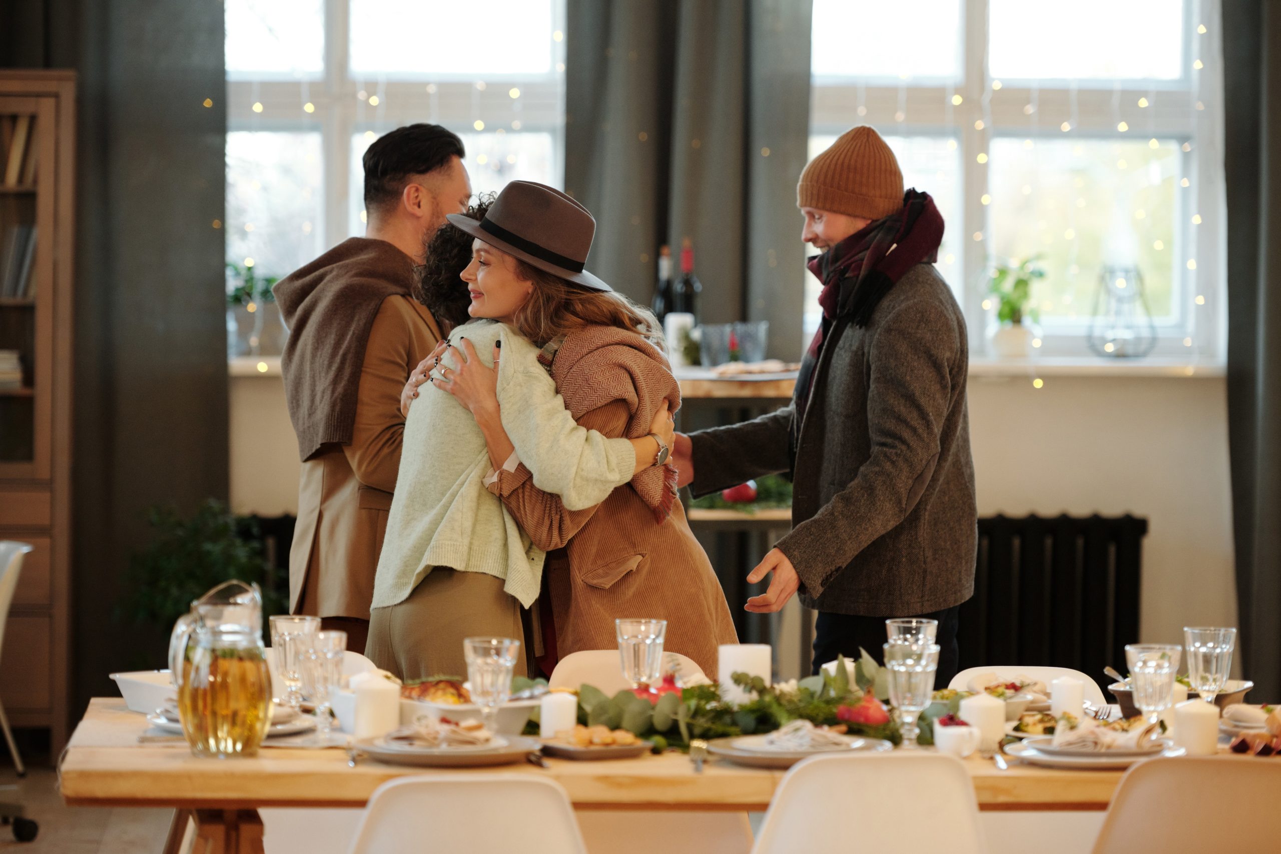 Photograph of people greeting and hugging with a table beautifully decorated